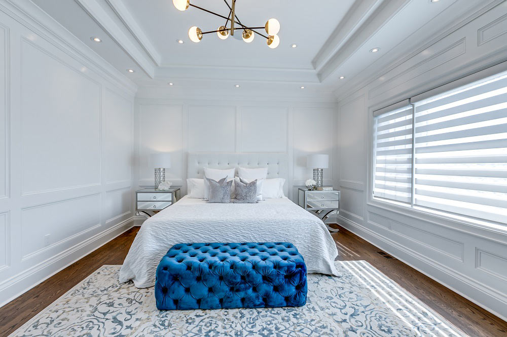 custom bedroom with coffered wall decor and baseboard trim - custom homes